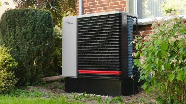 Outdoor heat pump unit installed beside a brick home