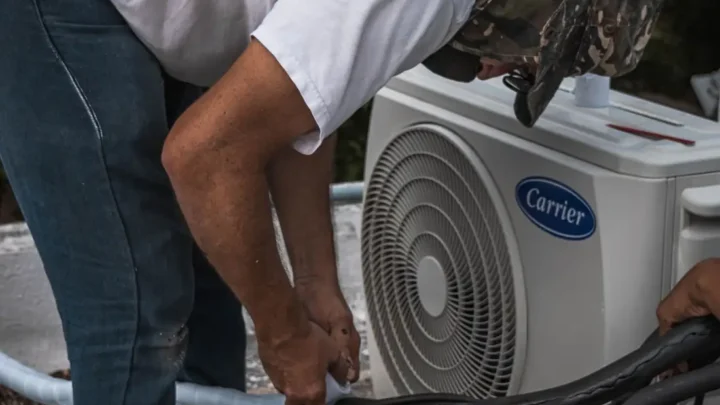 Technician performing maintenance on an outdoor air conditioning unit