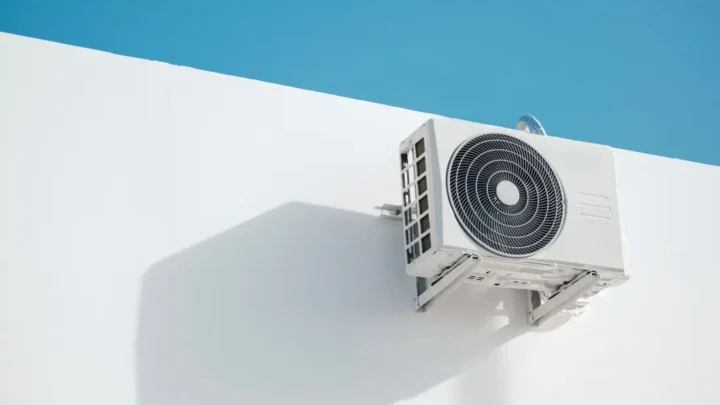 Wall-mounted air conditioner unit on a white building